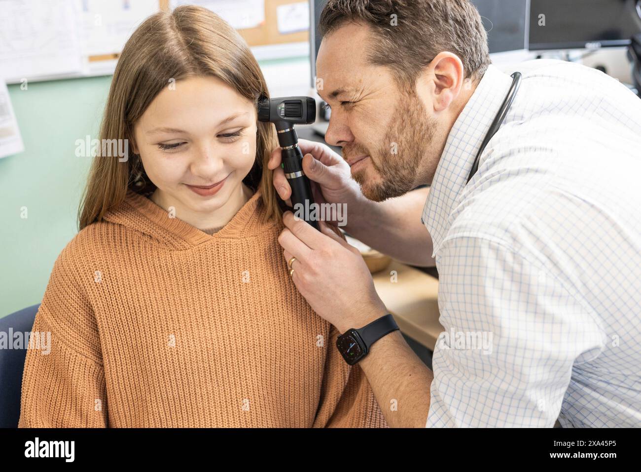 Doctor examining a young girl's ear with an otoscope Stock Photo
