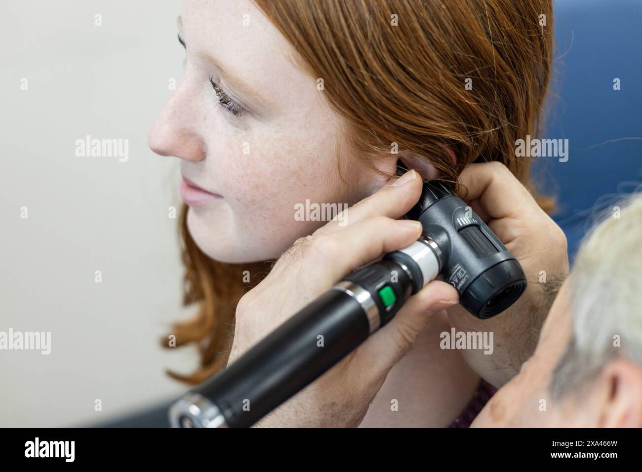 Woman performing an ear examination with an otoscope Stock Photo - Alamy