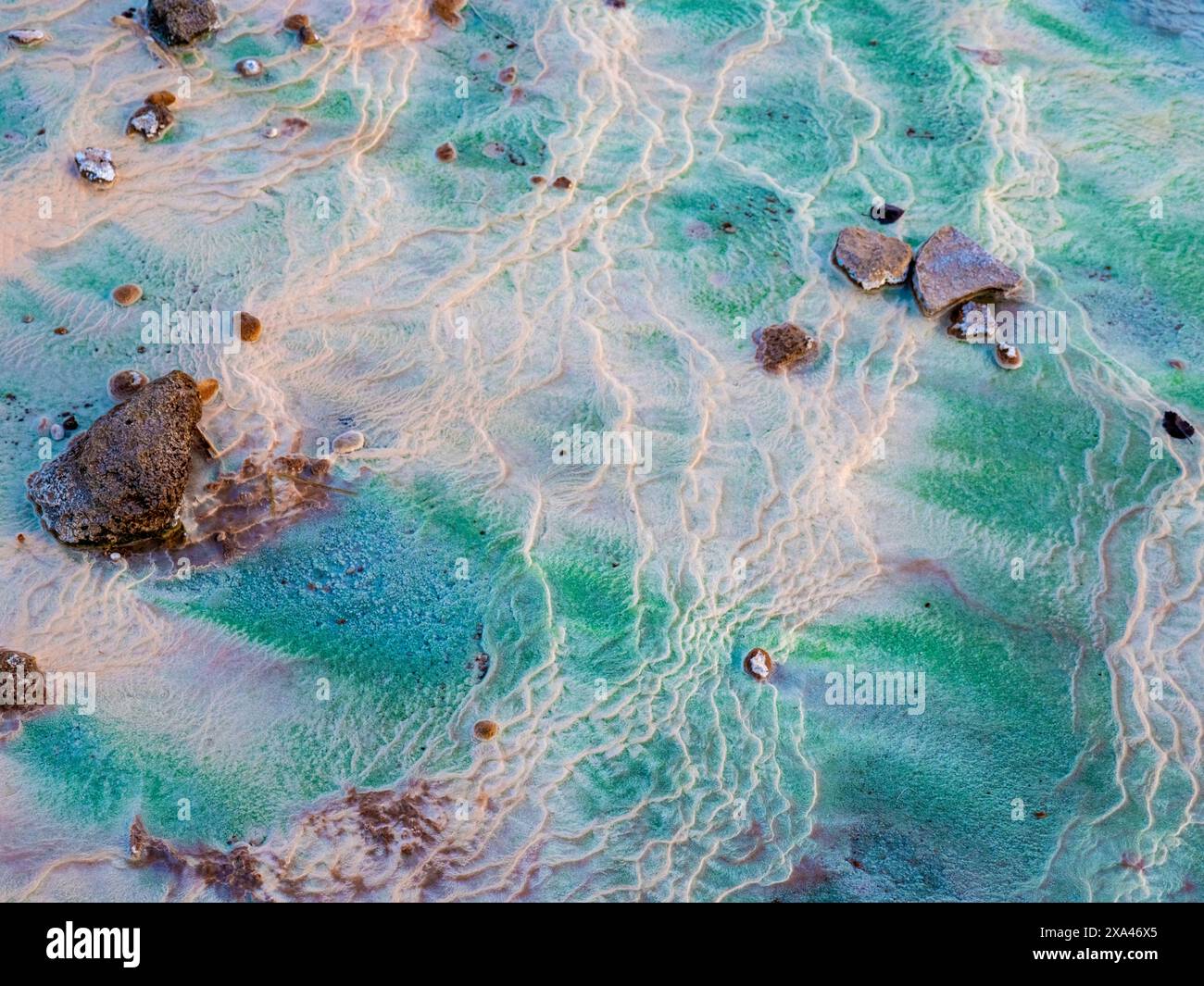 Textured hot spring with vibrant colors and stones Stock Photo