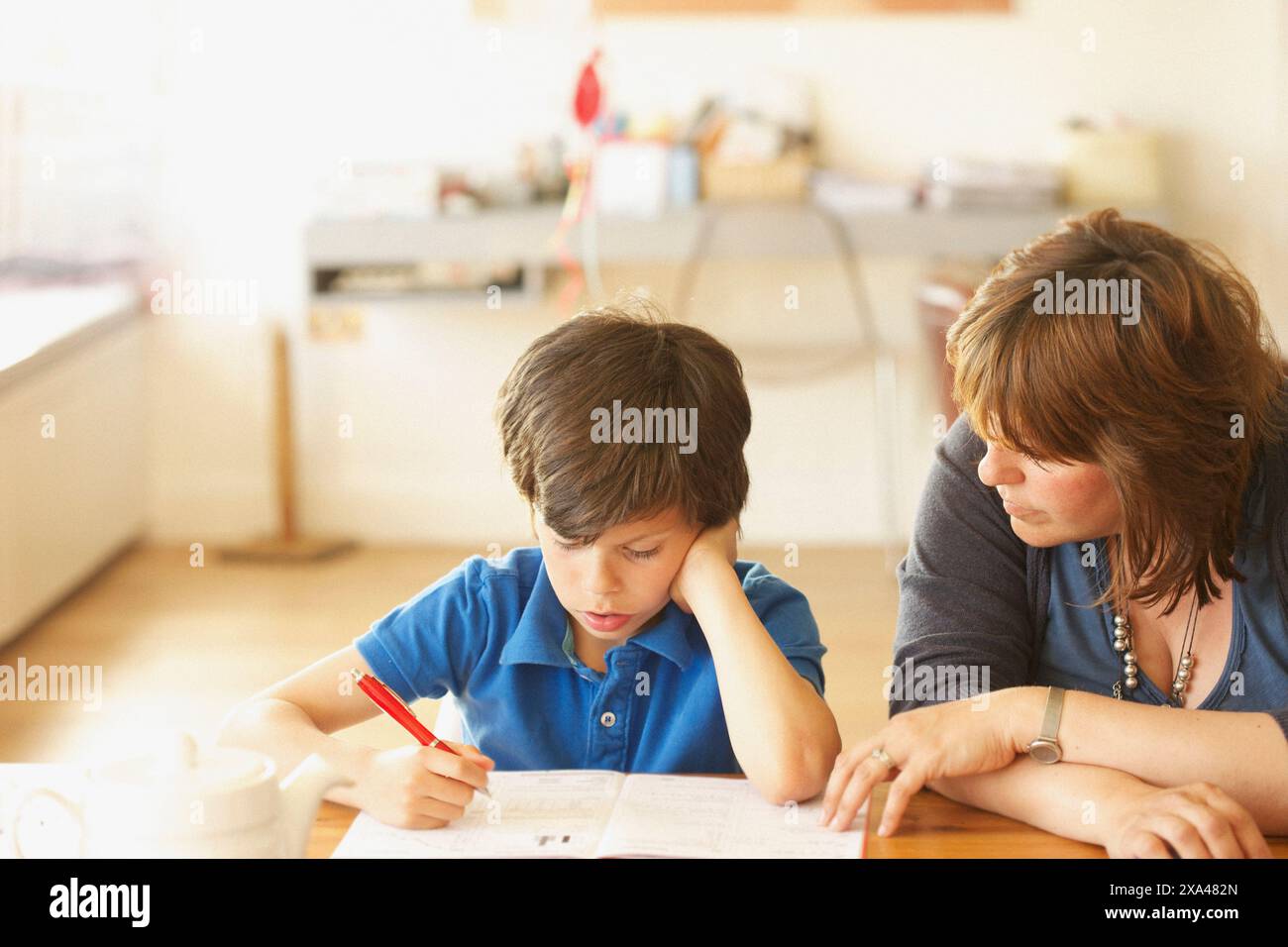 Mother and Son Doing Homework at Kitchen Table Stock Photo - Alamy