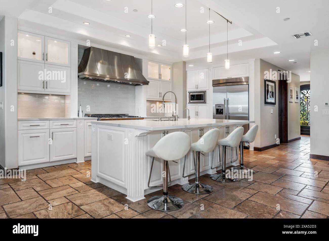 A modern kitchen with four bar counters and stools Stock Photo - Alamy