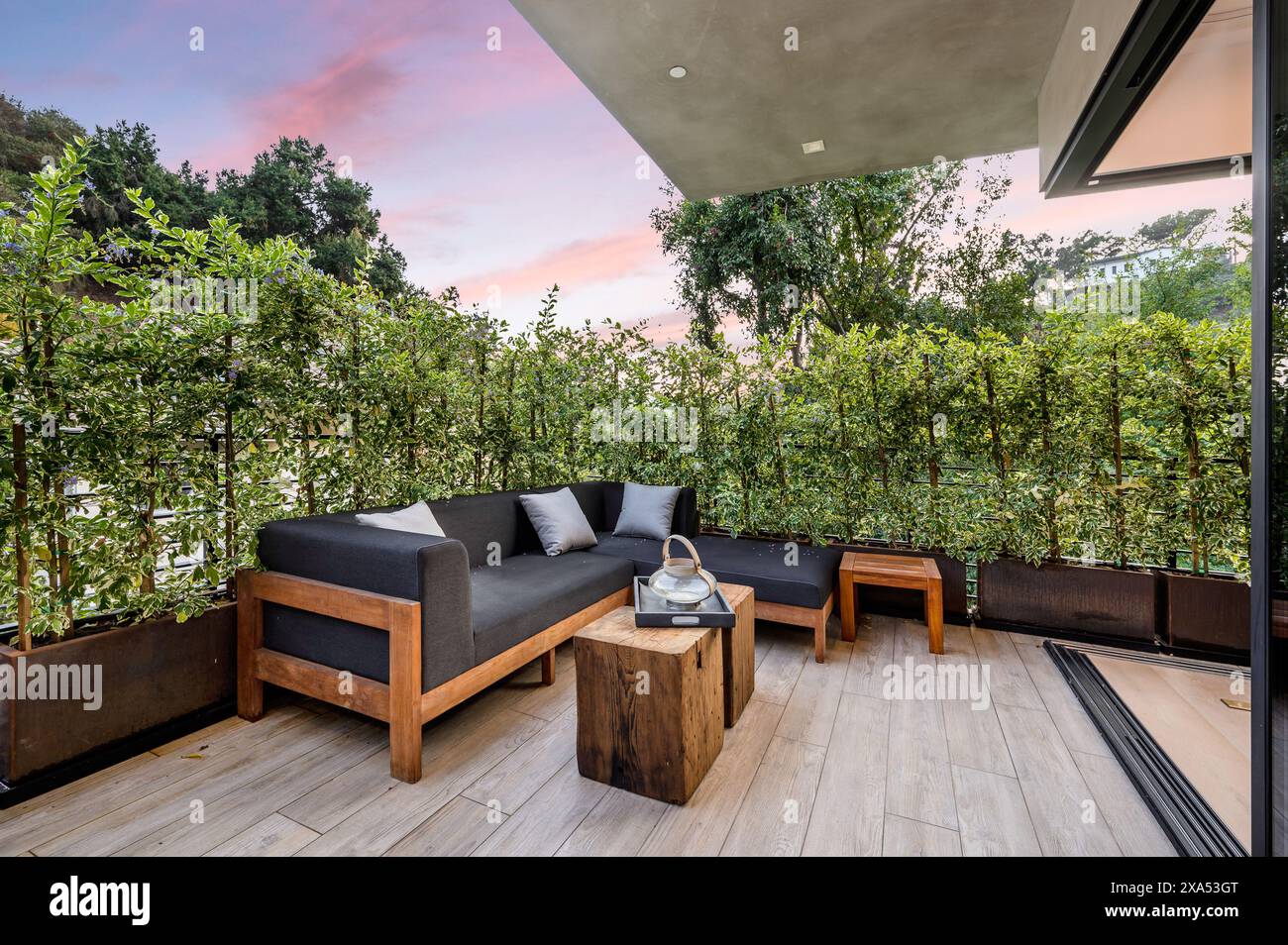 Wooden deck with furniture, plants, and fence enclosure Stock Photo - Alamy