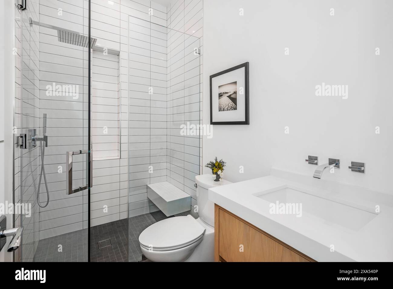 Modern bathroom with white and black subway tile, wooden cabinetry, and ...