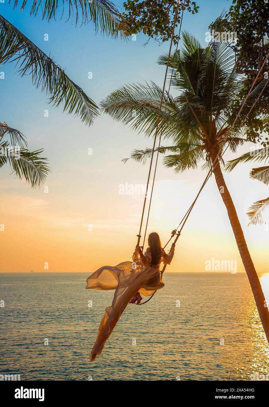 Woman on swing on the beach hi-res stock photography and images - Alamy