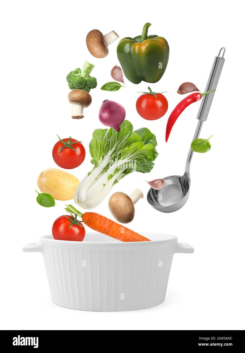 Fresh ingredients falling into saucepan on white background Stock Photo