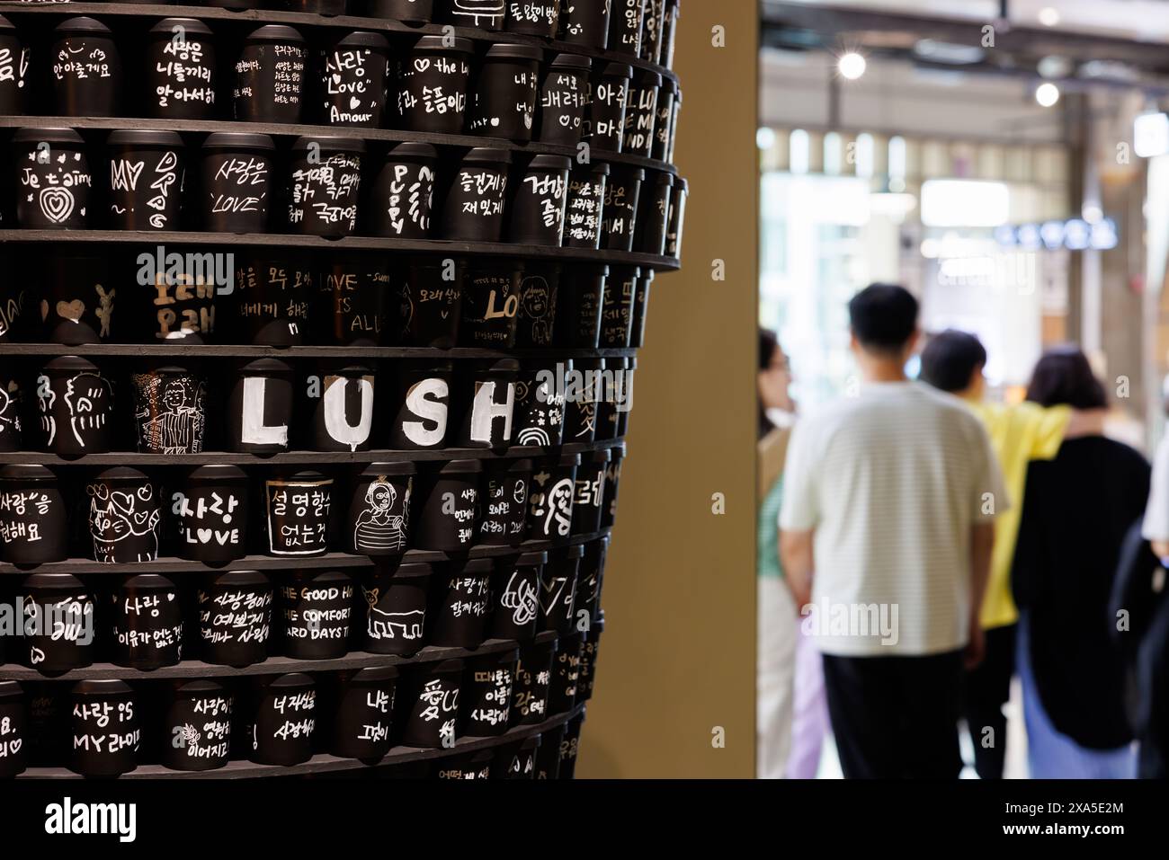The shoppers browsing an Asian store with 'lush' language signage Stock ...