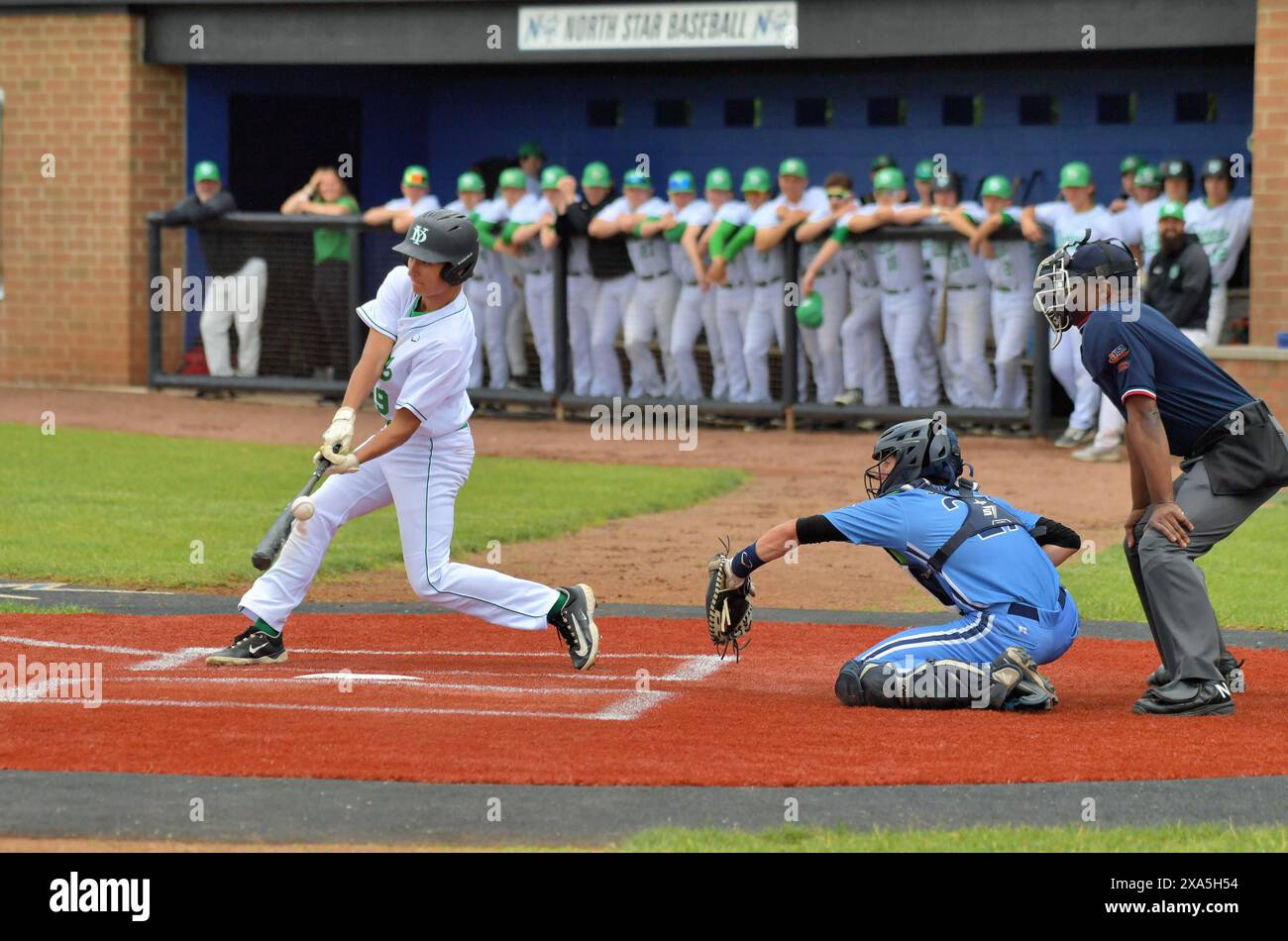 Illinois, USA. Batter swinging and missing a pitch during a high school