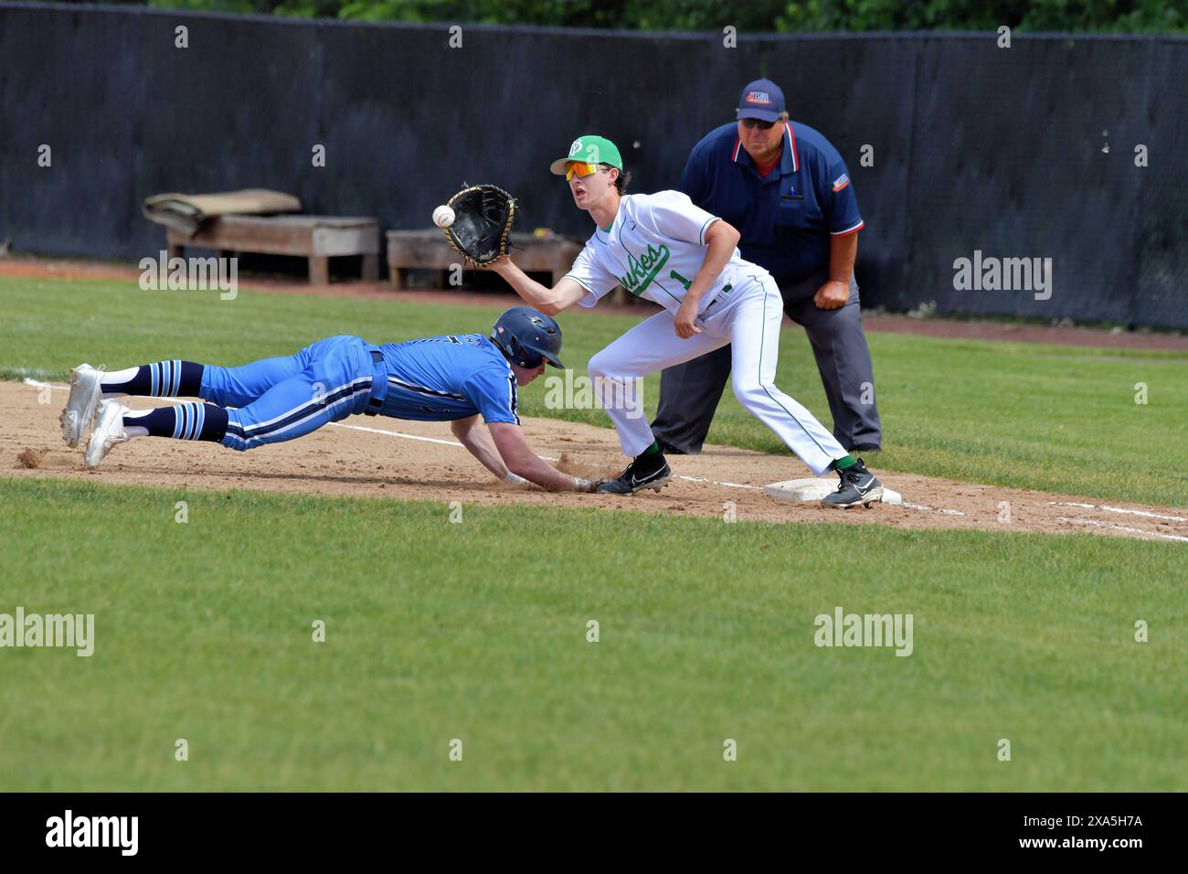 Illinois, USA. Frist baseman extends to reach a pick off throw attempt from his pitcher. Stock Photo