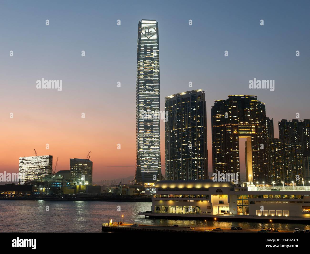 View of the sun setting behind the International Commerce Centre, Hong Kong's tallest building. Stock Photo