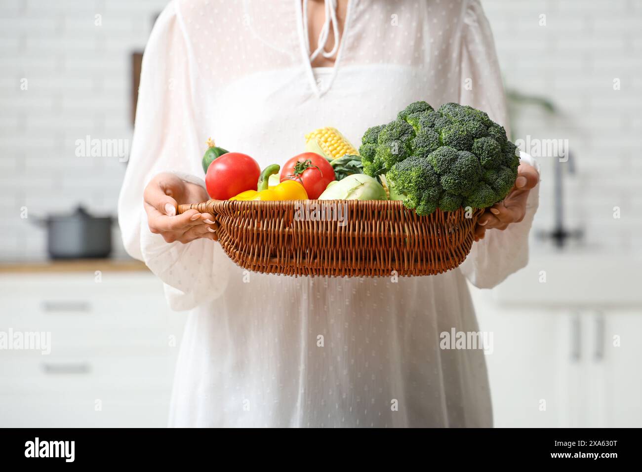 Pregnant woman holding wicker basket with different fresh vegetables in ...