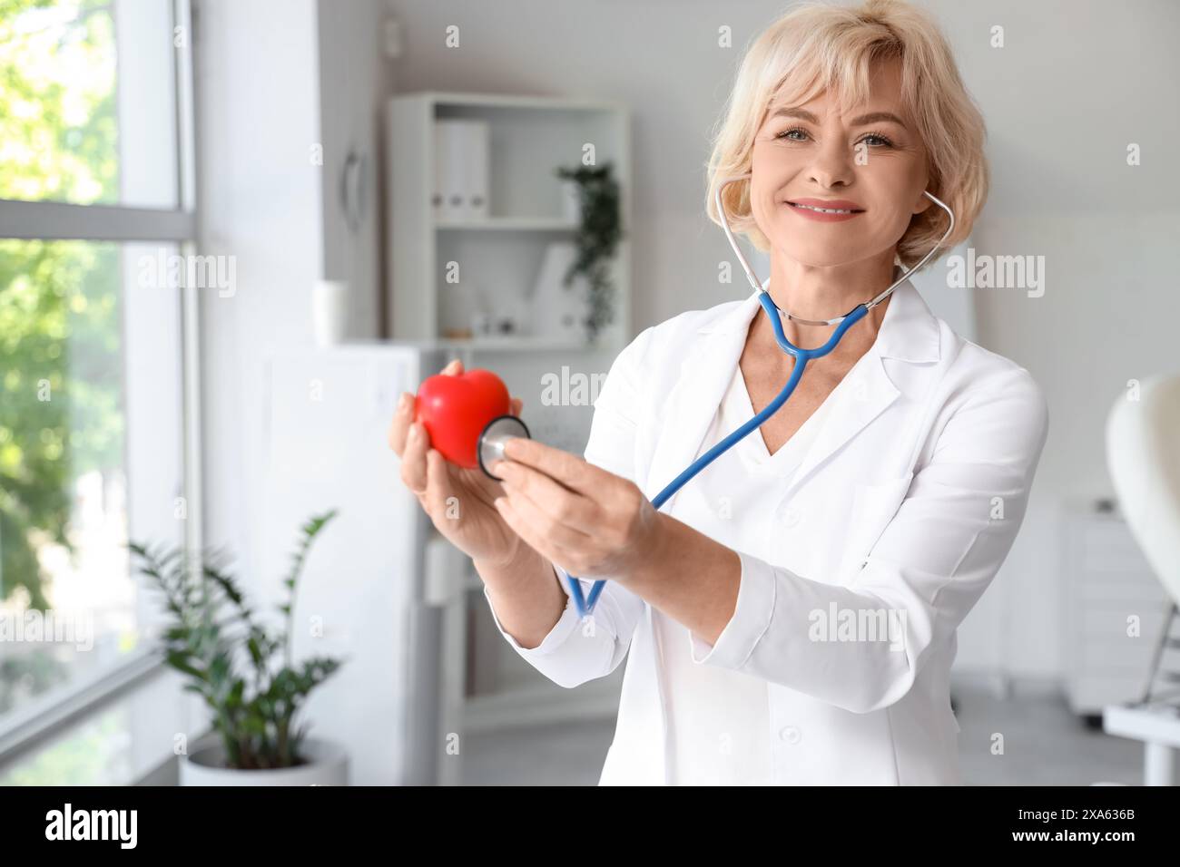 Female doctor with stethoscope listening to heart at hospital Stock ...