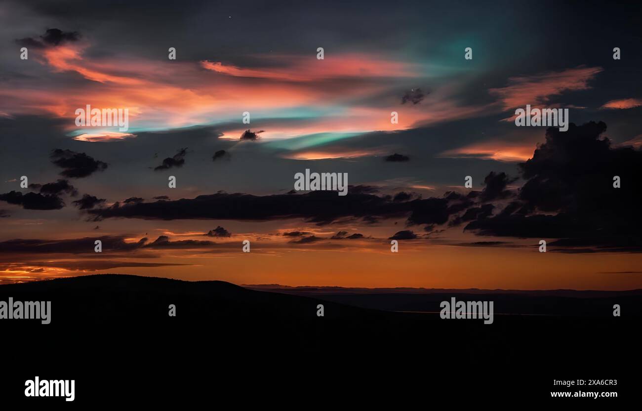 Vibrant nighttime sky with clouds in orange, blue, and green hues over mountain Stock Photo