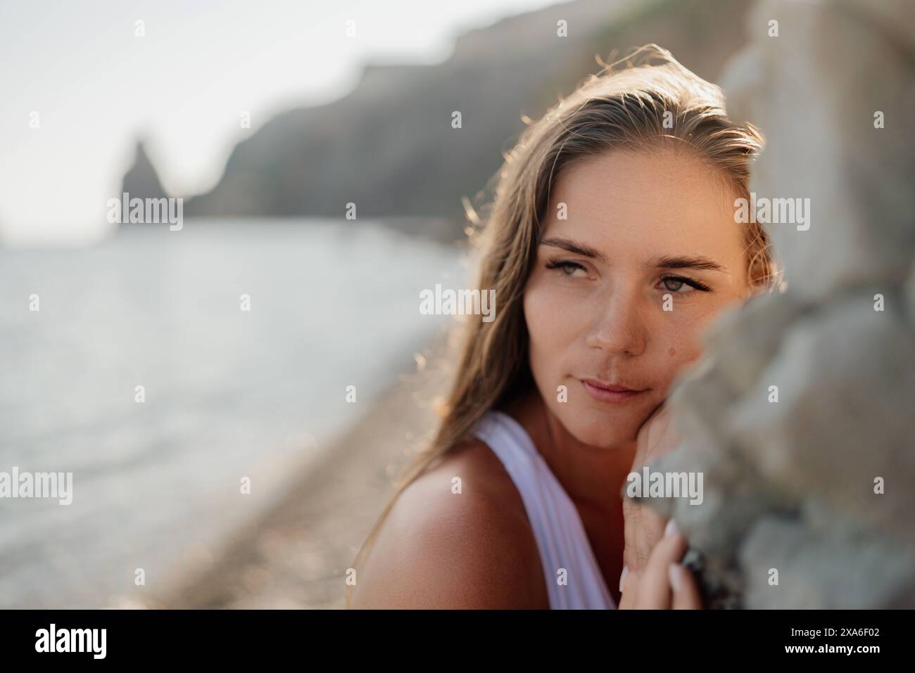 A woman with long hair is looking out at the ocean Stock Photo - Alamy