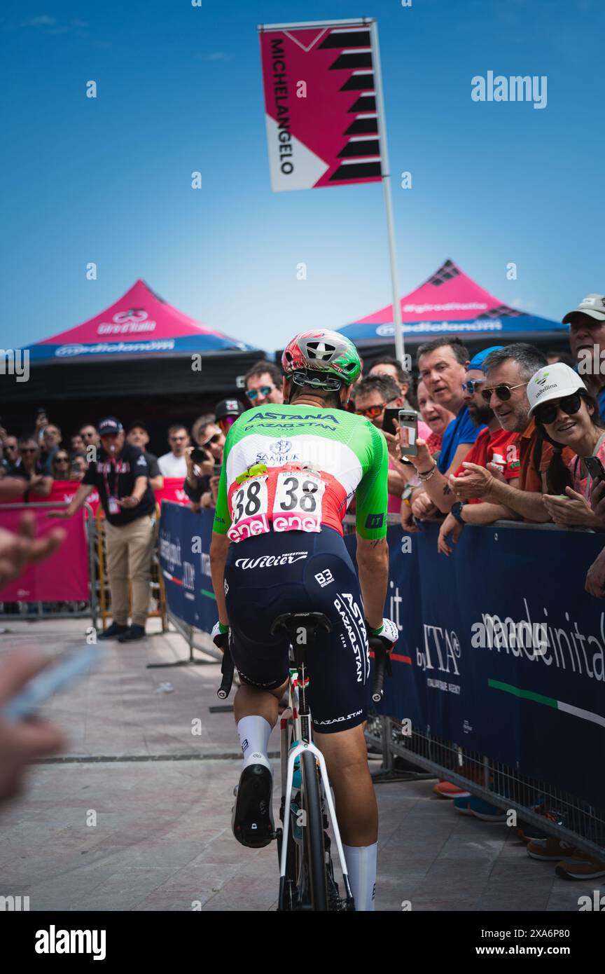 A man cycling through a crowd of people Stock Photo