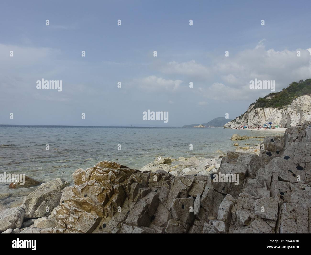 A rocky shoreline with sand and rocks on the beach Stock Photo