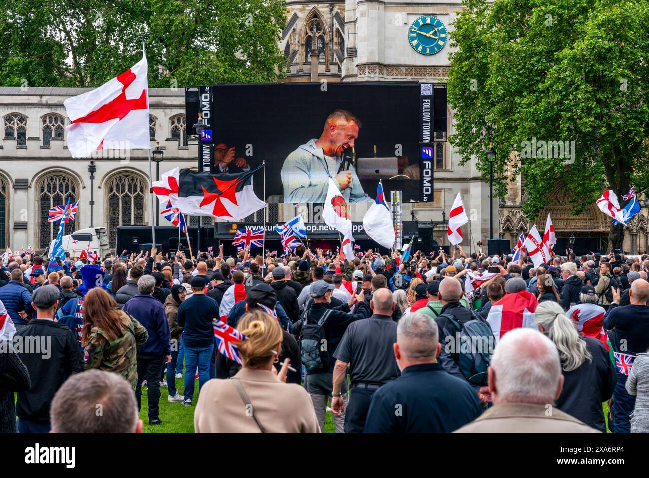 Political Activist Tommy Robinson seen on the big screen giving a speech after a rally against two tier policing, Parliament Square, London, UK Stock Photo - Alamy
