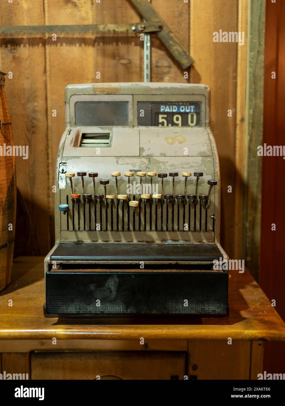 Vintage cash register by wooden walls, beside a basket Stock Photo