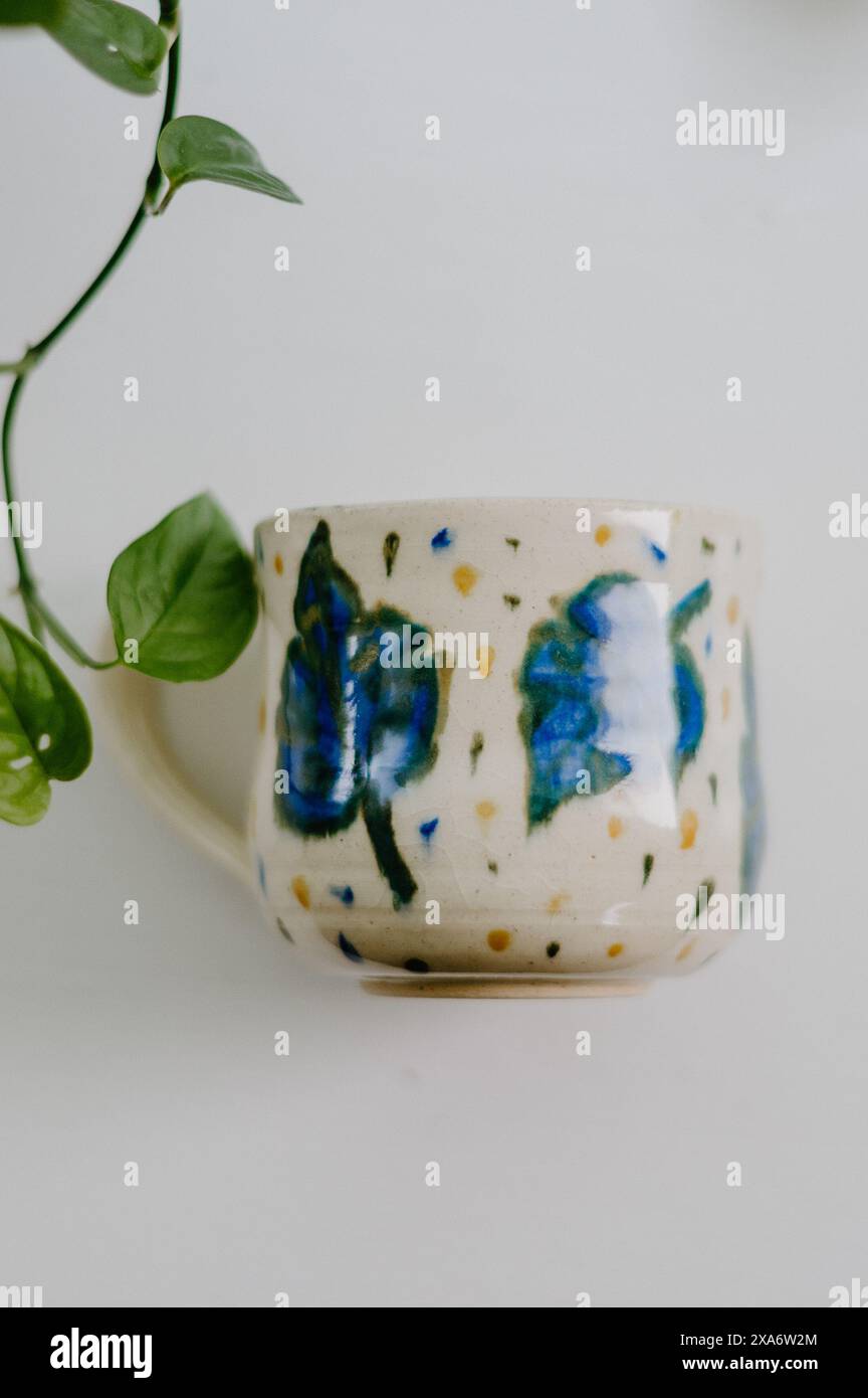 The beautiful hand-made ceramic mug displayed on the table Stock Photo