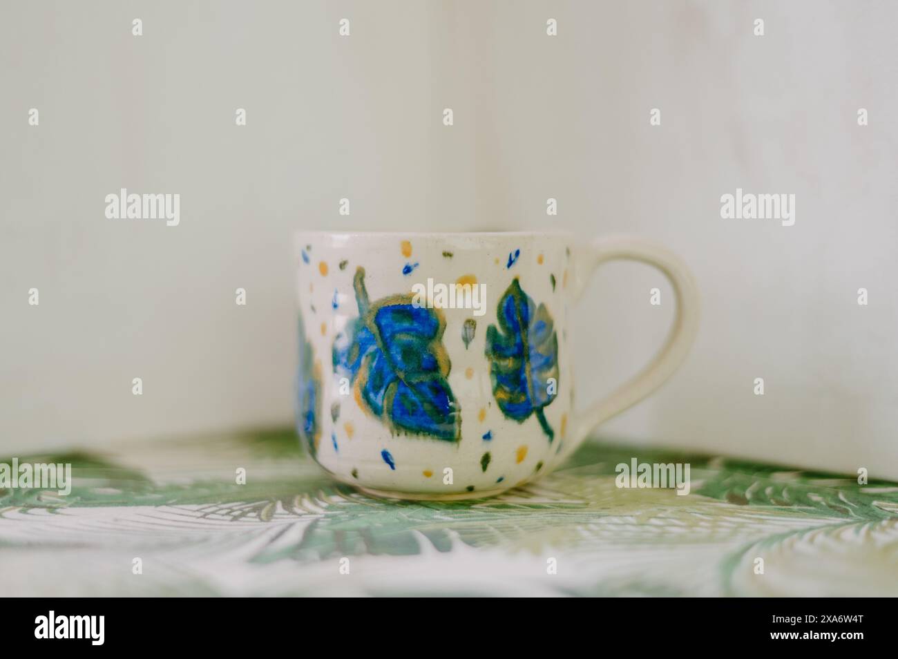 The beautiful hand-made ceramic mug displayed on the table Stock Photo