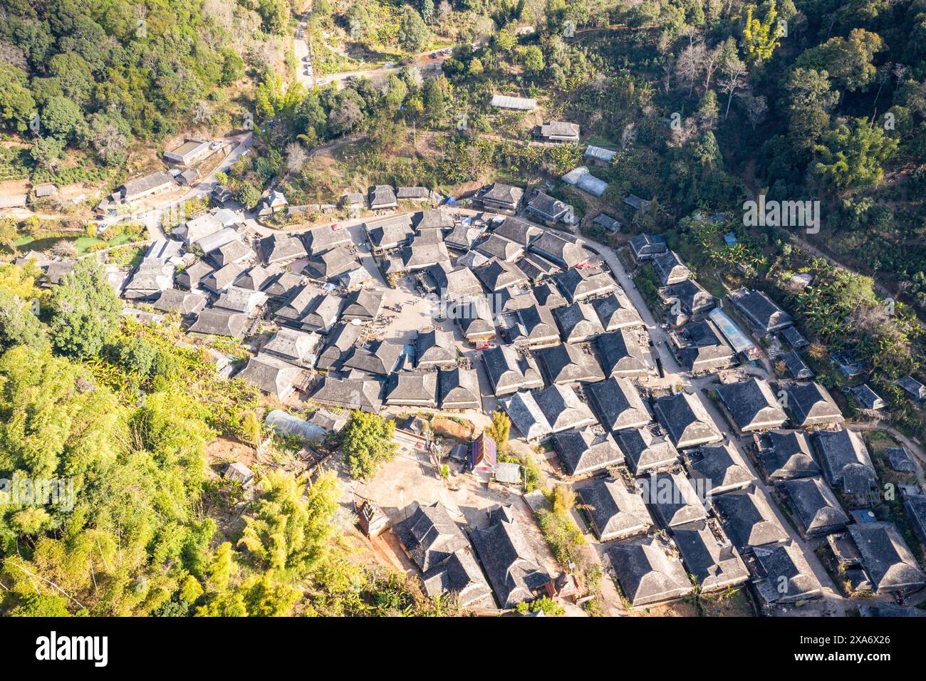An aerial view of a village nestled among trees and hills Stock Photo ...