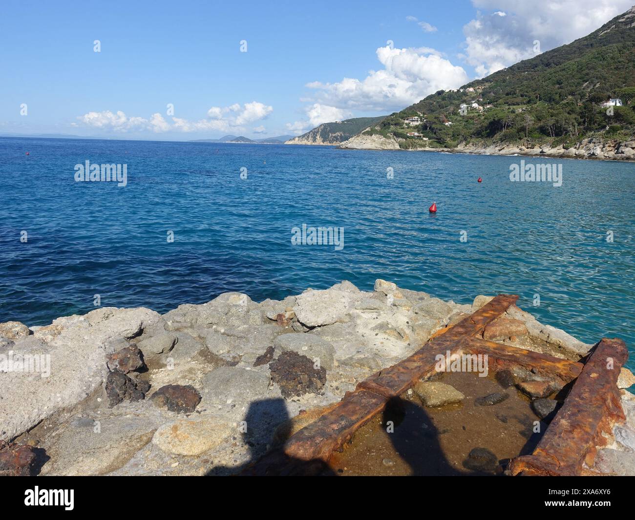 A rocky shoreline with calm water Stock Photo