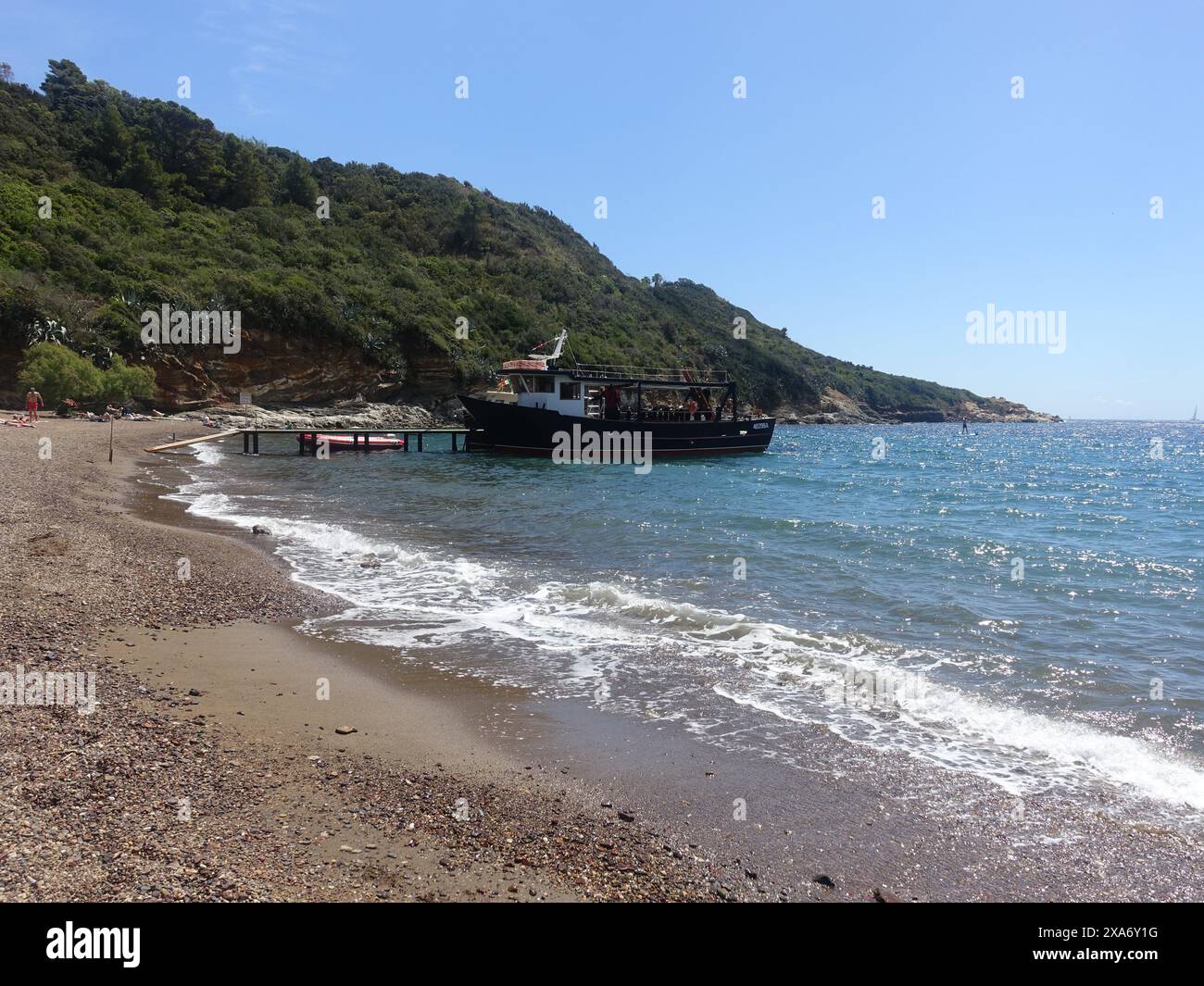 A shot of a boat on the shore near mountains and a water surface Stock Photo