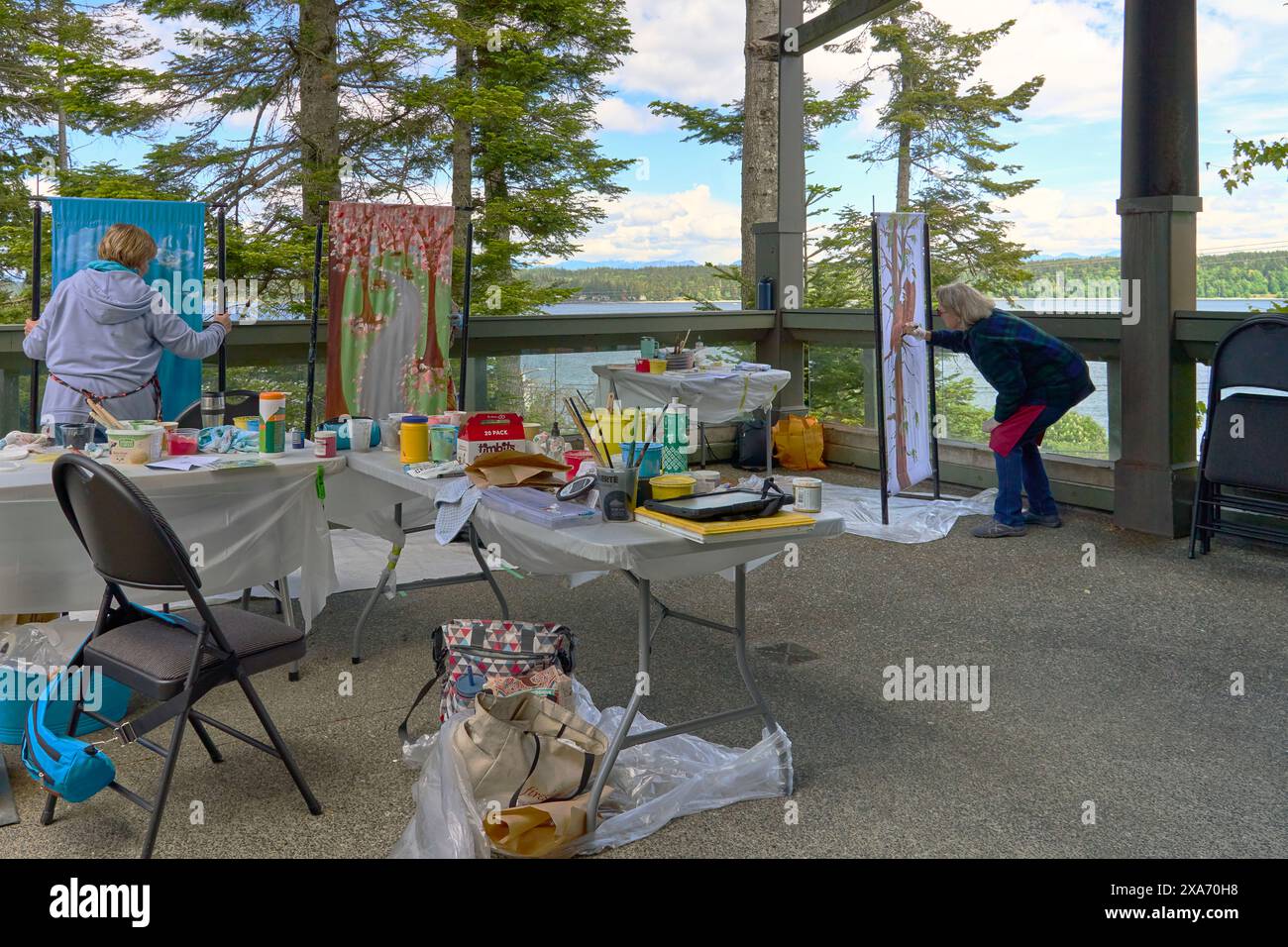 Artists painting banners outside at the Campbell River Museum Stock