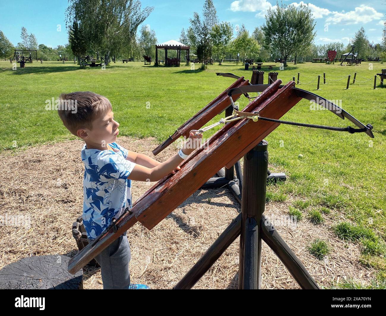 A small child holding a wooden crossbow Stock Photo
