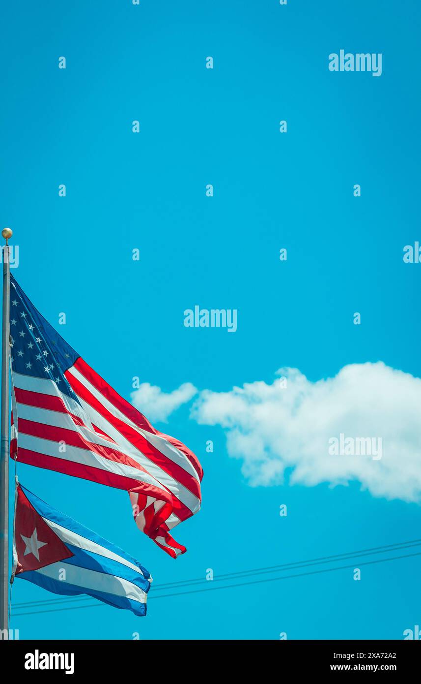 The flags of the USA and Cuba against the blue sky Stock Photo