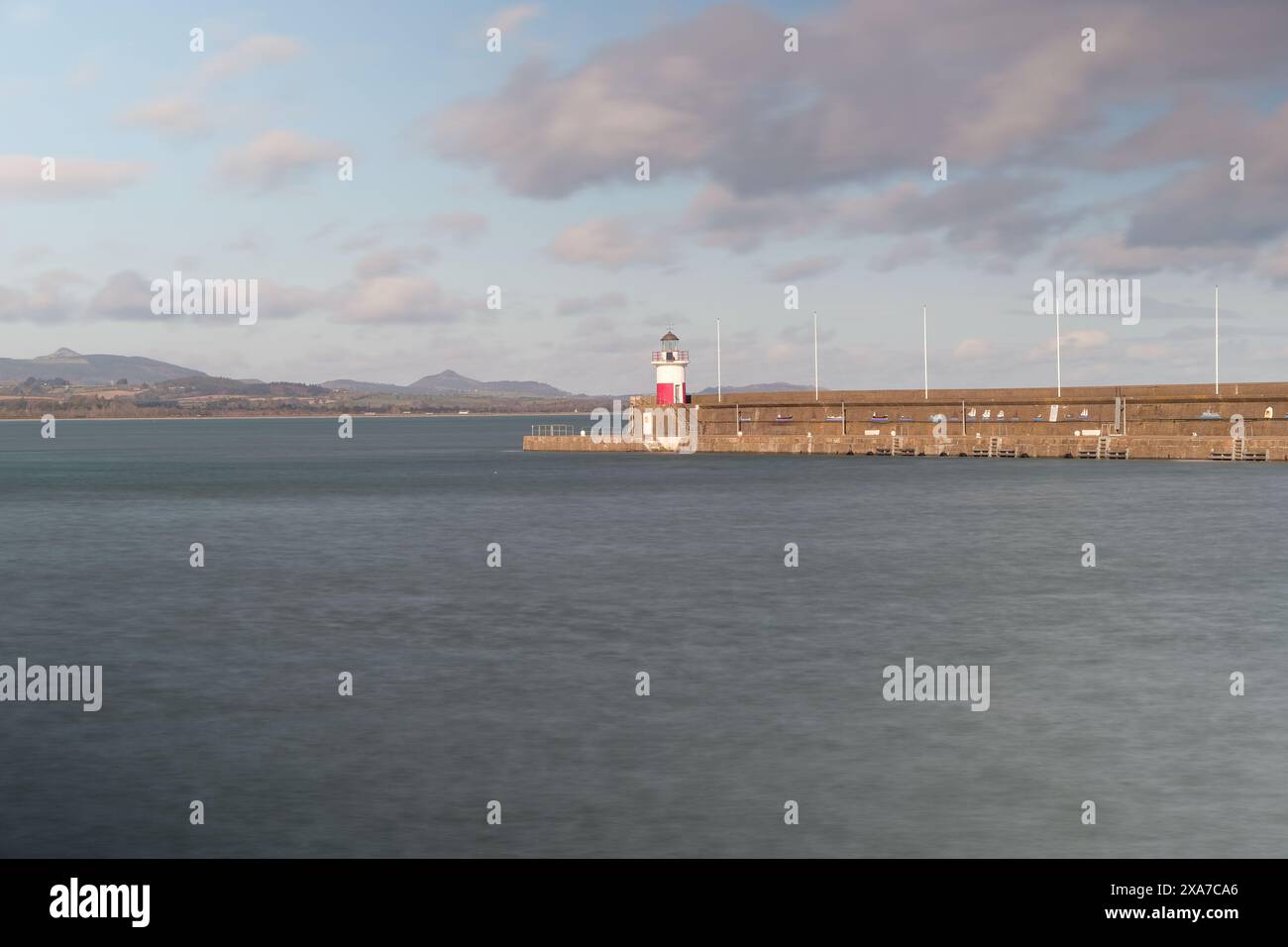 Lighthouse by the ocean under cloudy skies Stock Photo