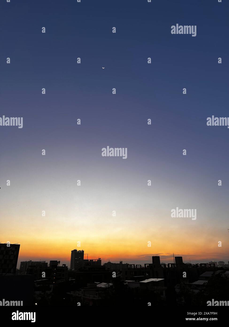 Sunset over city skyline with buildings in silhouette Stock Photo - Alamy
