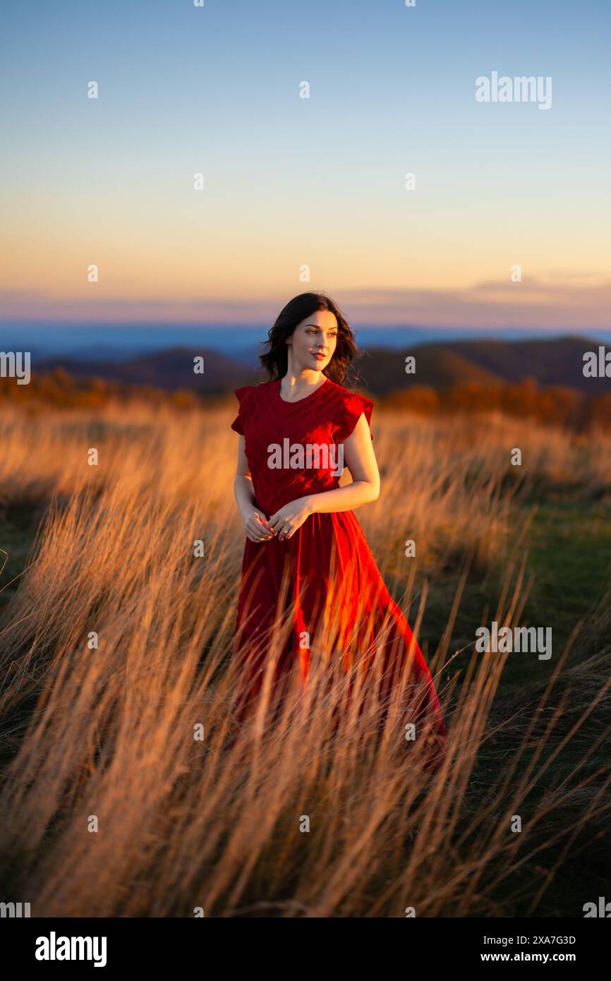 A female standing in a field of tall brown grass Stock Photo