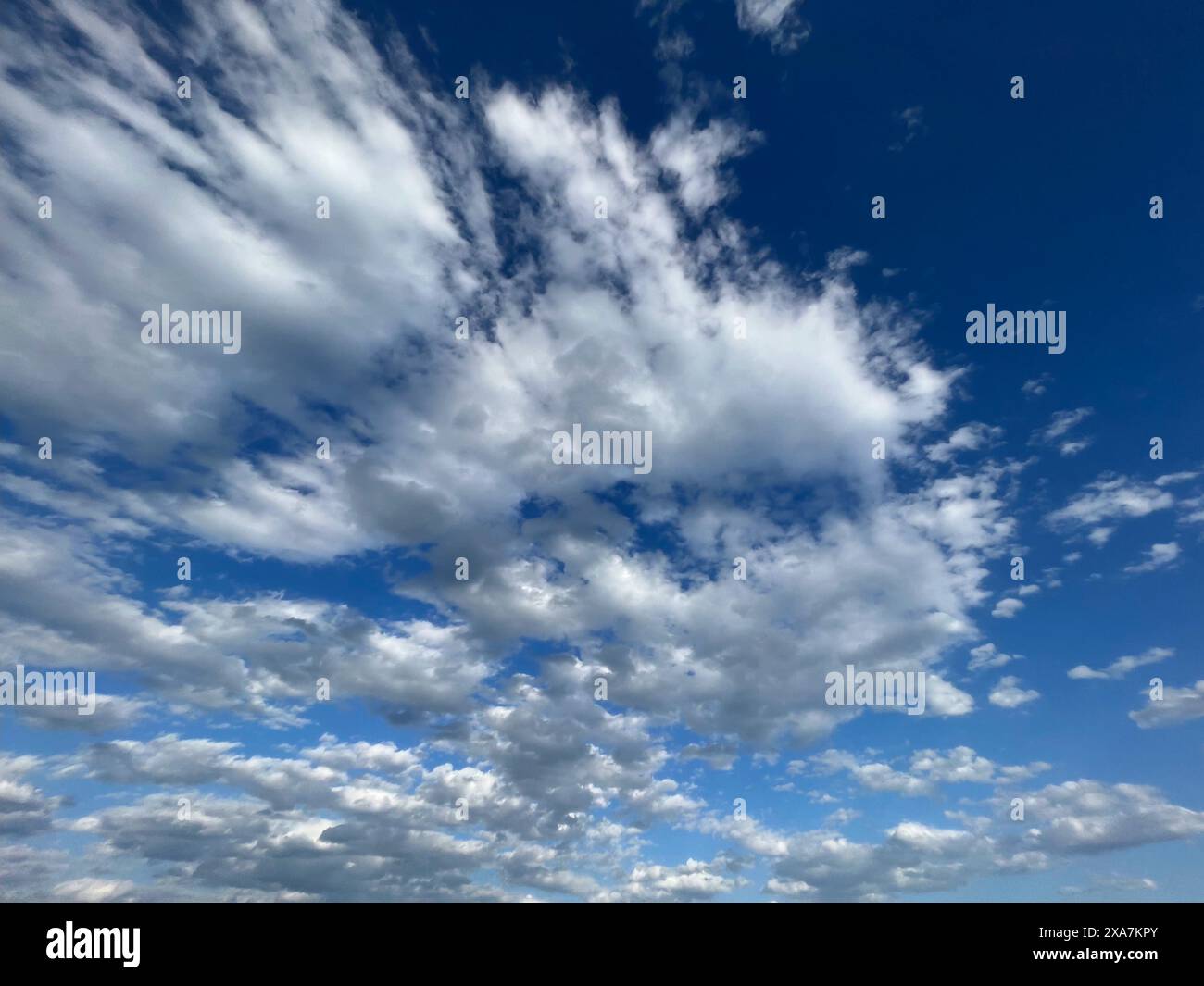 Bright blue sky with an assortment of fluffy clouds on a sunny day ...