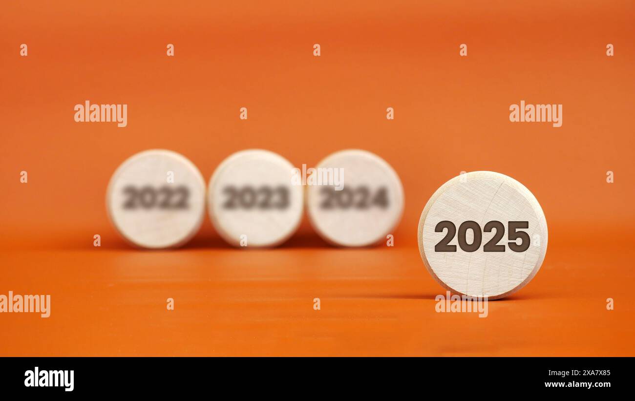 Closeup spotlight on 2025 engraving on wood with blurred background of 2022, 2023, 2024 Stock
