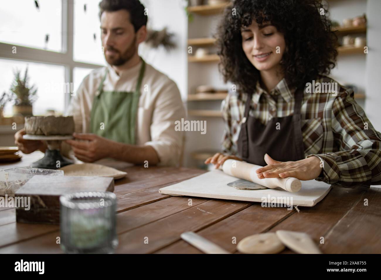 Mature man and woman sculpting clay together in a pottery class Stock ...