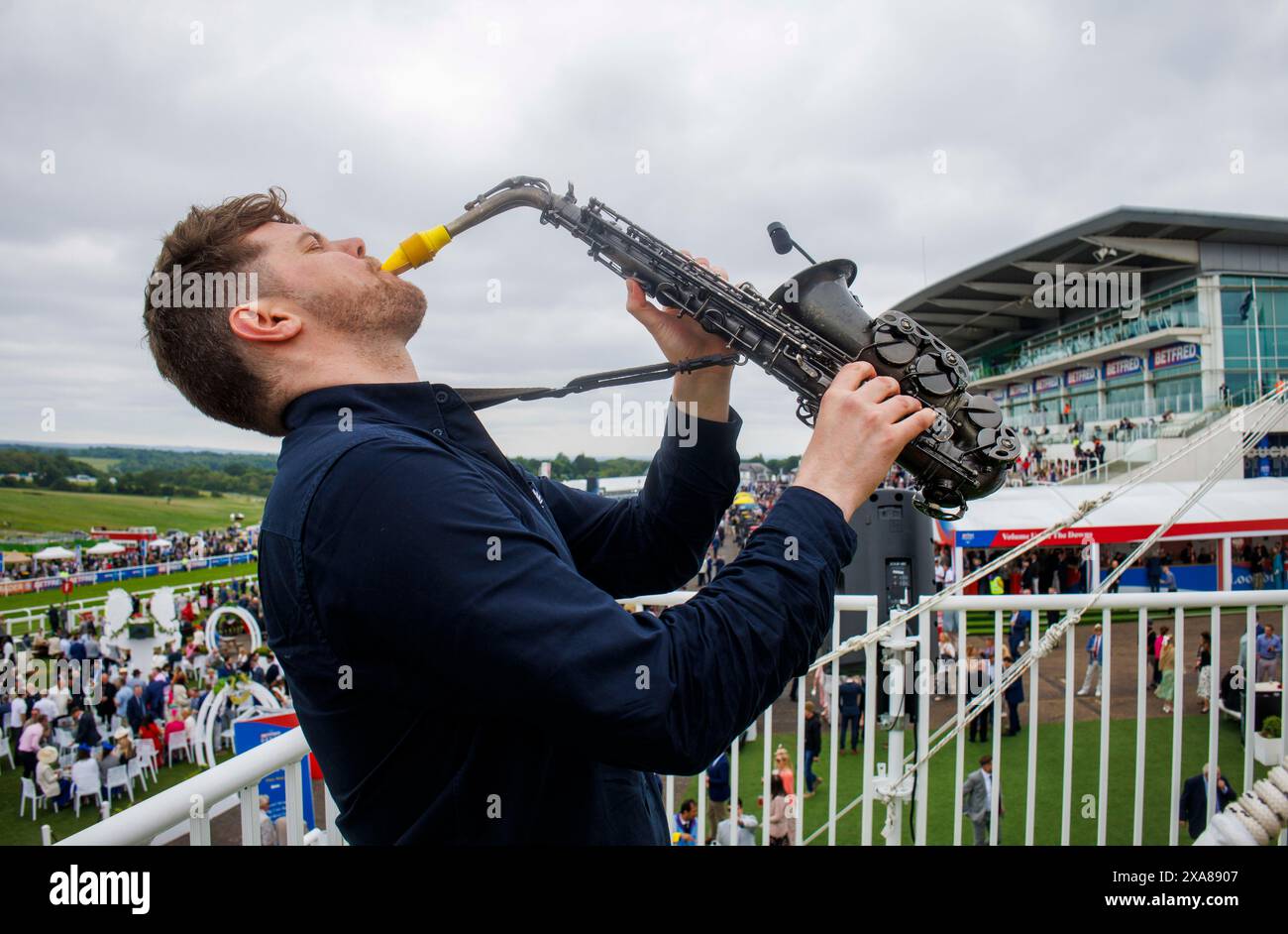 A saxophonist plays on Derby day at Epsom race course. The Derby is one of the Classic flat races. The Derby Stakes is a Grade 1 Flat race Stock Photo
