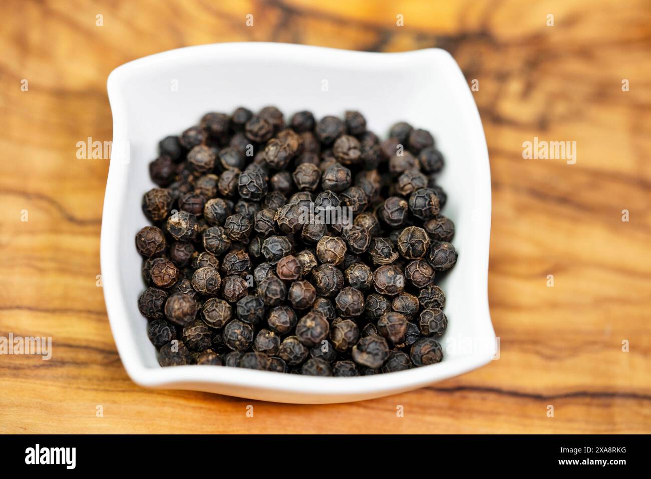 black pepper (Piper nigrum), black Kampot pepper in a porcelain bowl Stock Photo