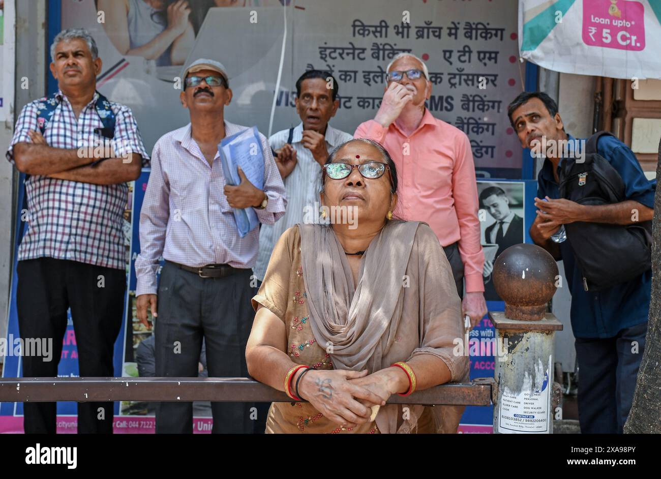 People watch election results and its impact on the stock market on the screen outside the Bombay Stock Exchange (BSE) building. The stock market was volatile when it opened in the morning due to election result, there was an anticipation of Bharatiya Janata Party (BJP) getting the majority of the votes and Prime Minister Narendra Modi getting elected for the third time, but that wasn't the case as opposition parties gave tough fight to the Bharatiya Janata Party (BJP) as votes were being counted and result was flashed on the screen which impacted the stock trading heavily. (Photo by Ashish Va Stock Photo