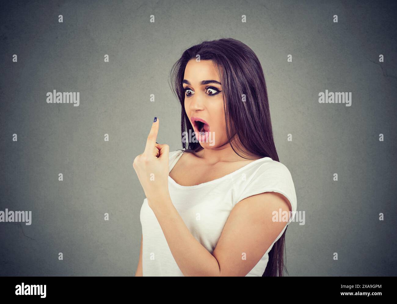 shocked young woman looking at her index finger Stock Photo