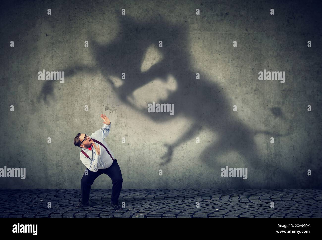 Business man scared by his monster shadowBusiness man scared by his monster shadow Stock Photo