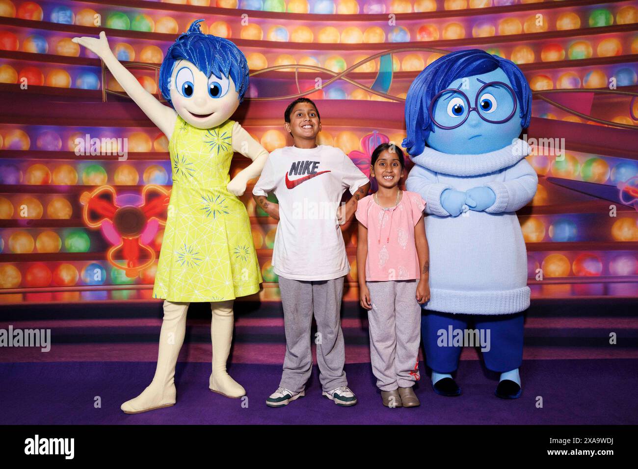 EDITORIAL USE ONLY (Left to Right) Joy, Paarth, (age 9),Tulsi (age 6), and Sadness during a visit by CEO of The Walt Disney Company, Bob Iger (not pictured) and characters from Inside Out 2 to Great Ormond Street Hospital for Children to announce funding for a new state-of-the-art MediCinema onsite. Issue date: Wednesday June 5, 2024. Stock Photo