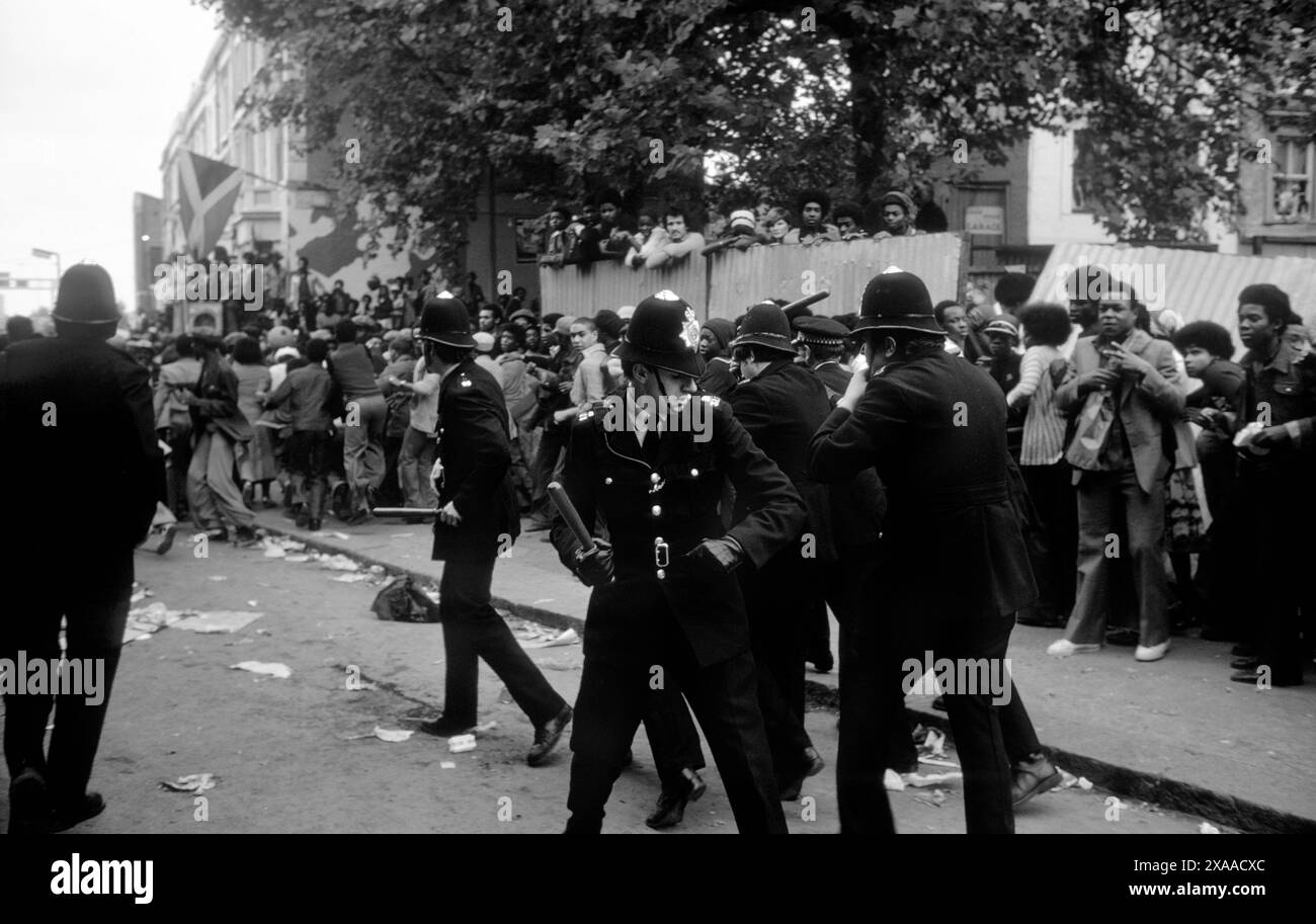 1970s UK, inner city urban violence, riots, British police truncheons drawn, group together for self protection. They have no shields or protective clothing. Notting Hill carnival riot London, England 30th August. 1976 HOMER SYKES Stock Photo