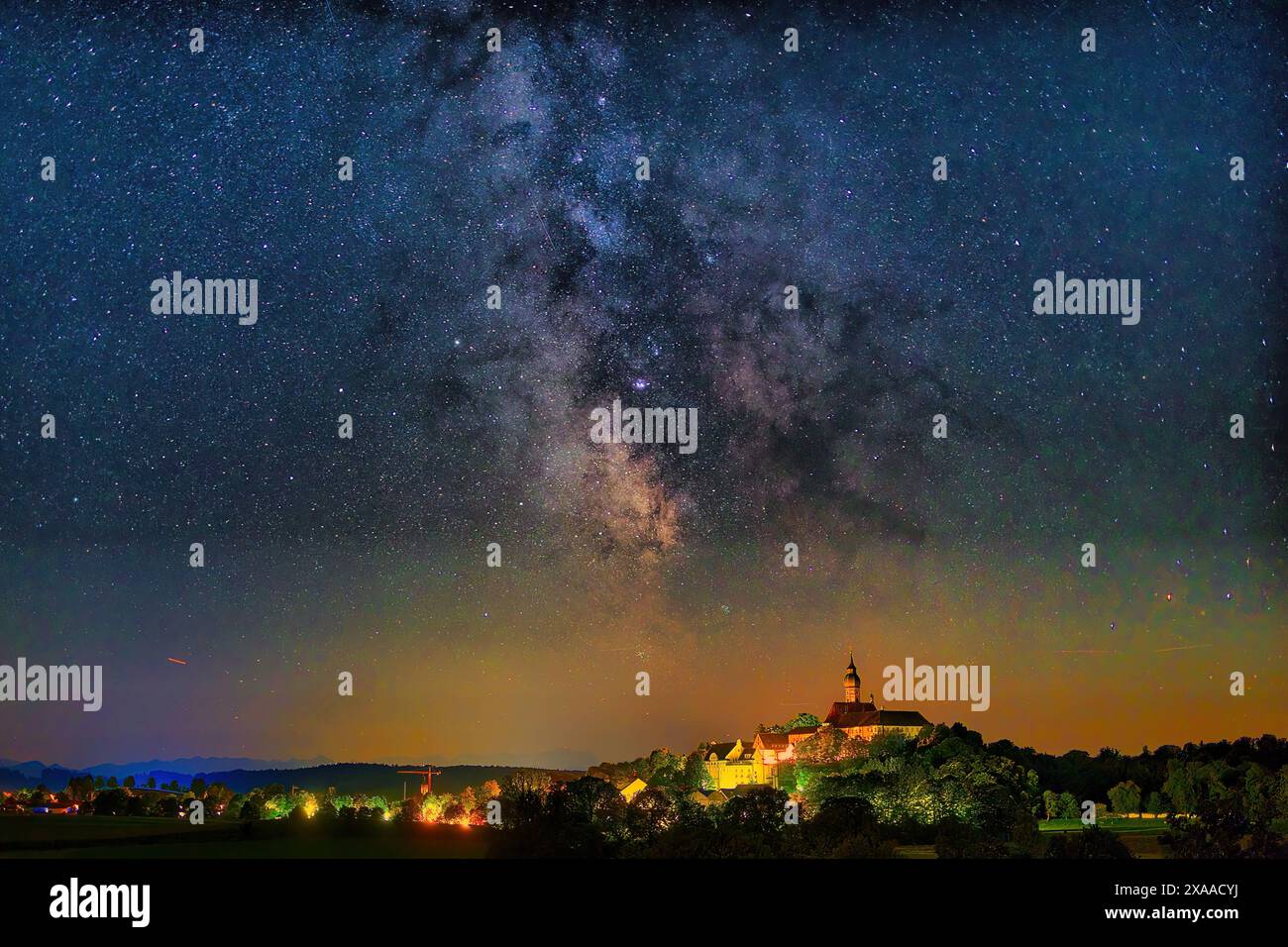 A starry night sky with clouds above historic village Stock Photo - Alamy