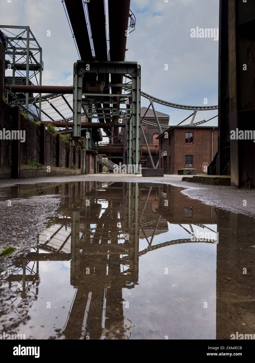 An old factory building reflected in the puddle. Hochofen, Germany ...