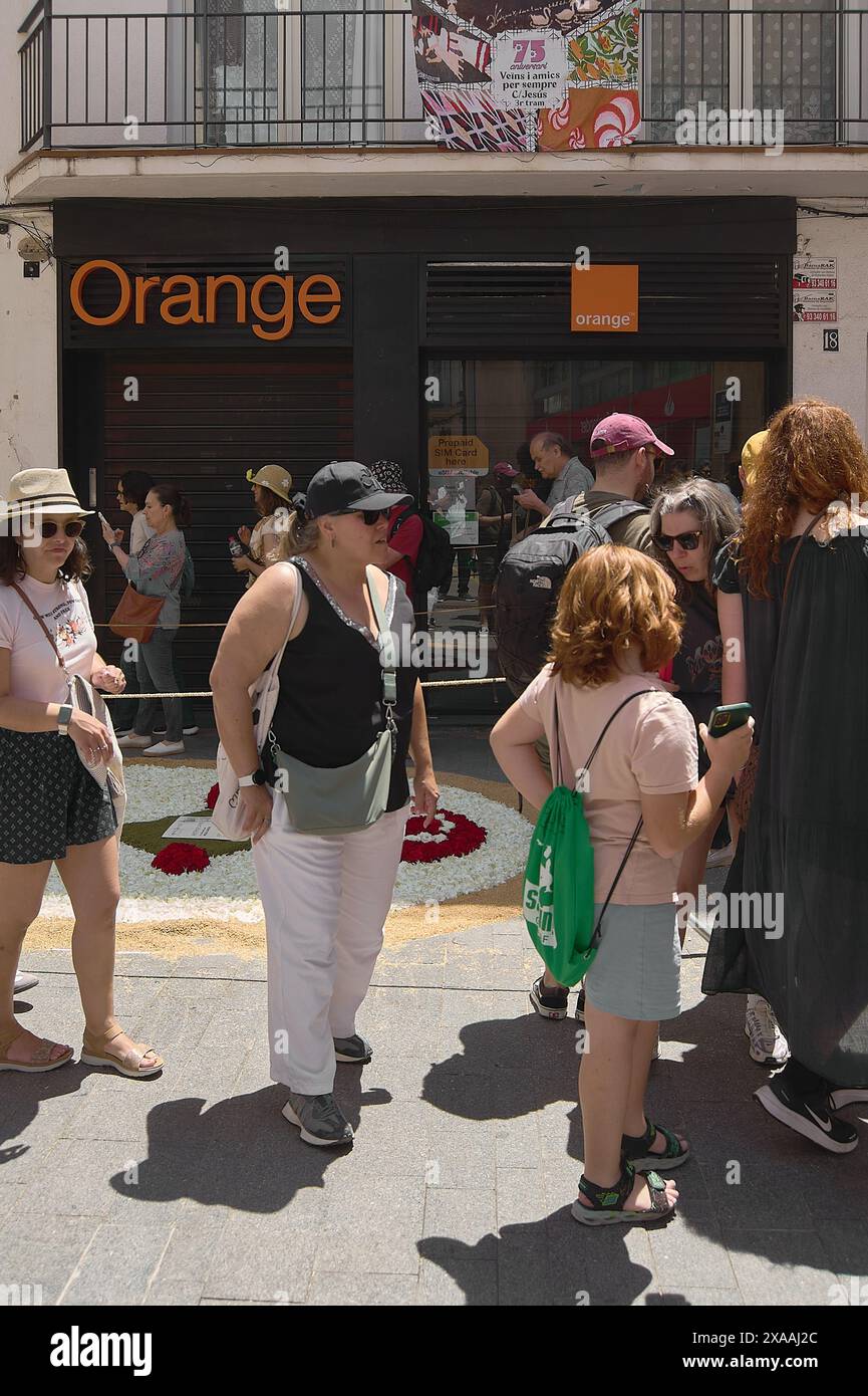 Sitges, Barcelona, Spain-June 03, 2024: View of a busy urban street with pedestrians and the facade of an Orange store on a sunny day. The image captu Stock Photo