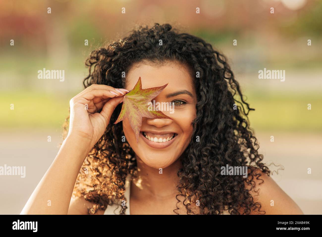 Woman Holding Leaf in Front of Face Stock Photo - Alamy