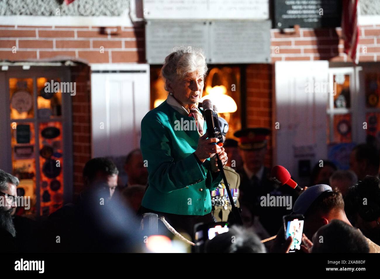 84-year-old Arlette Gondree speaking before giving a champagne toast to D-Day veterans at 2316 in the evening, marking the exact moment 80 years ago that British troops entered her family's cafe in Benouville, Normandy, France, making them the first family to be liberated from German control. Picture date: Wednesday June 5, 2024. Stock Photo