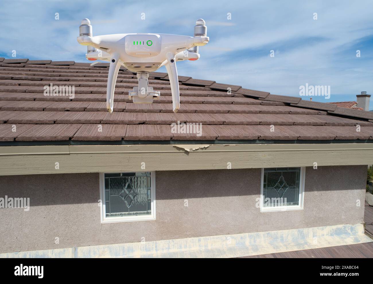 Quadcopter UAV Drone Flying A Residential Roof Inspection Stock Photo
