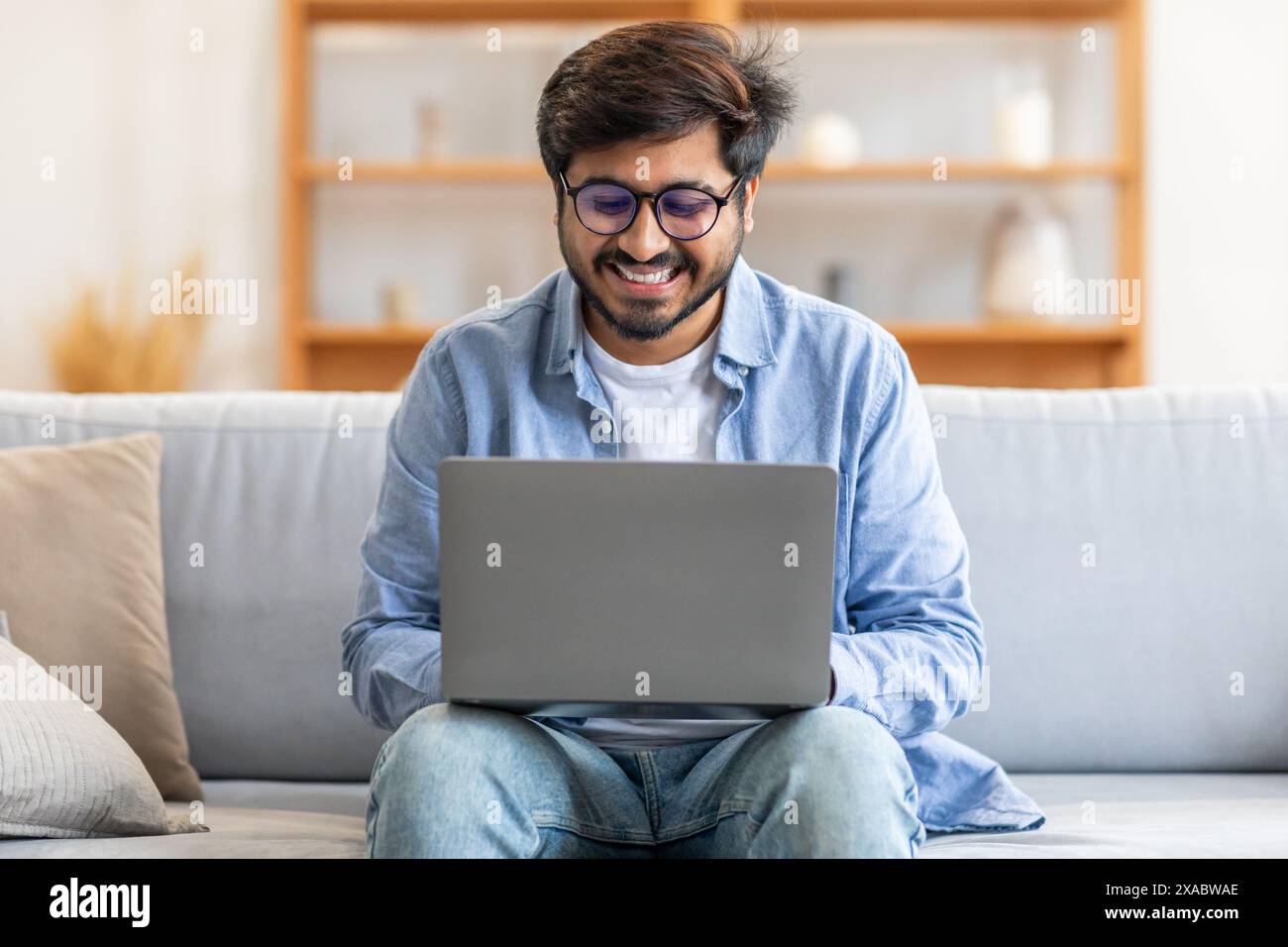 Man Sitting on a Couch Using a Laptop Stock Photo