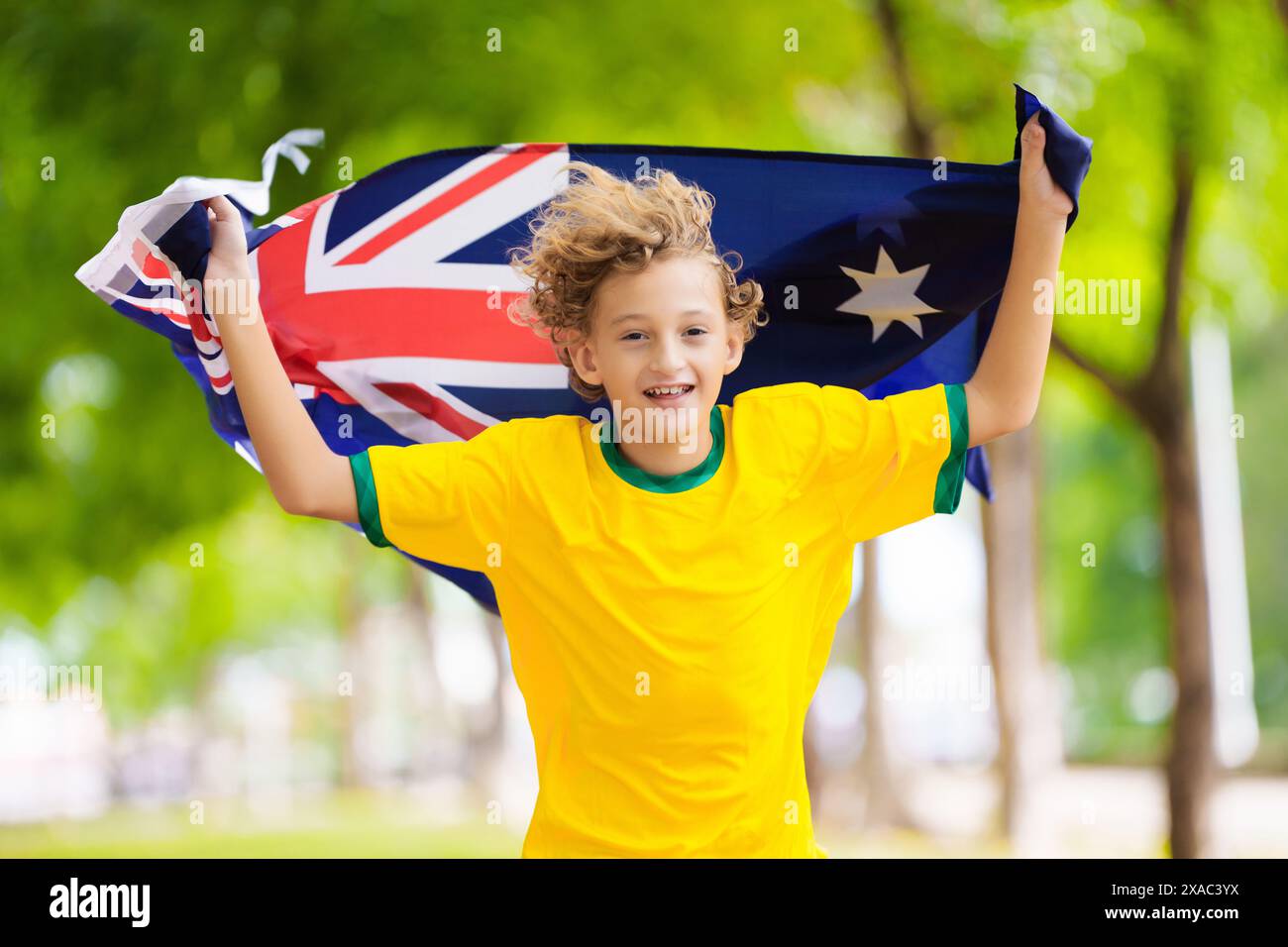 Australia team fans with flag. Australian supporter child. Kid cheering for Aussie football or cricket team victory. Happy little boy national flag Stock Photo